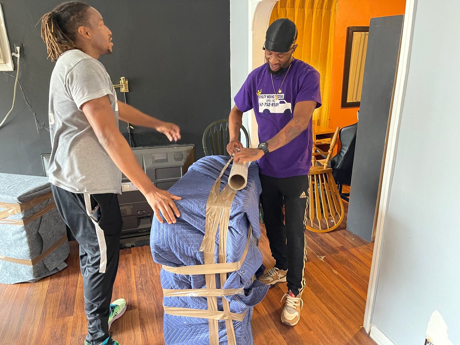 Royalty Moving crew carrying boxes into a home on moving day