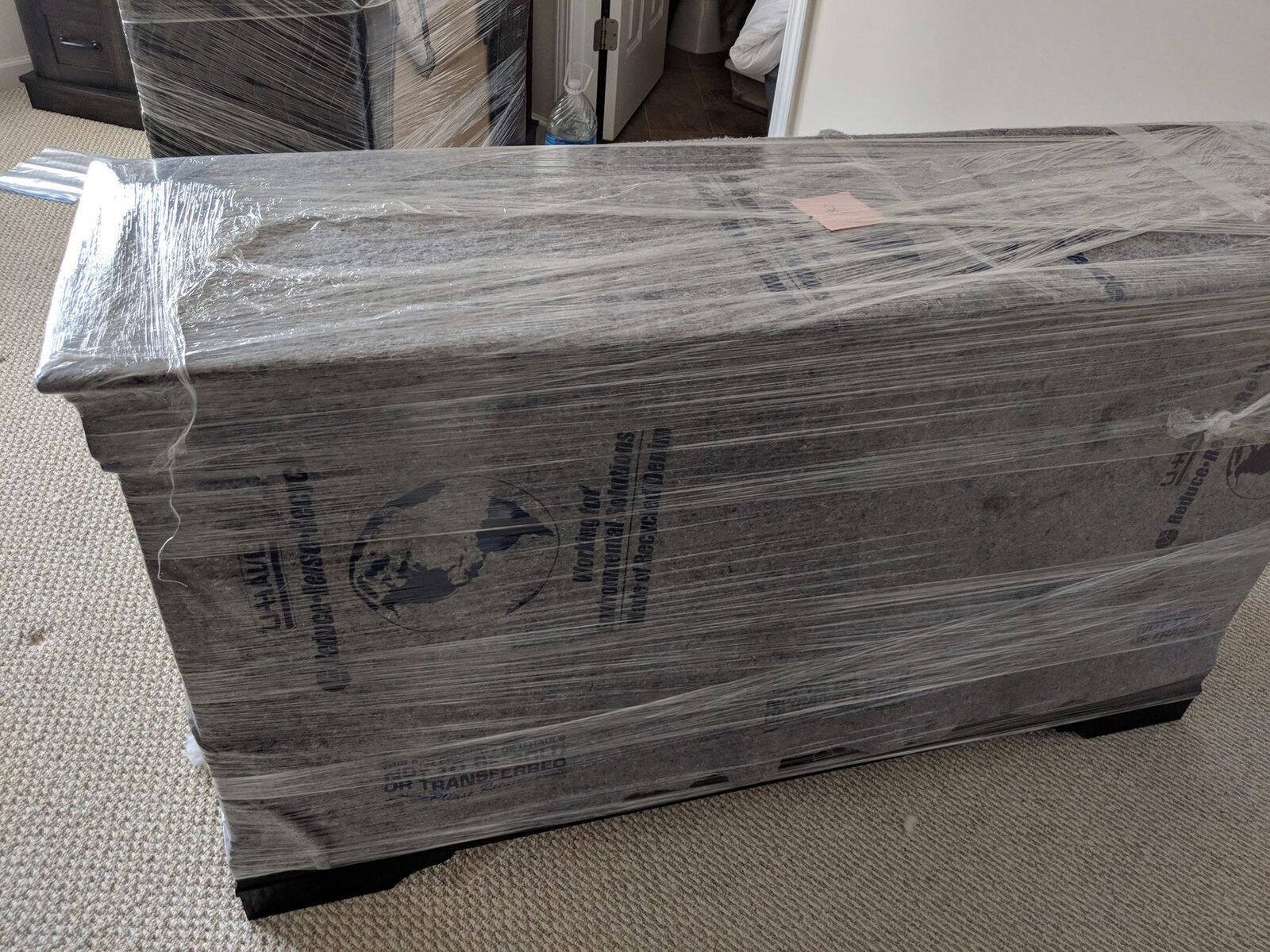 A large piece of furniture fully shrink-wrapped for the move