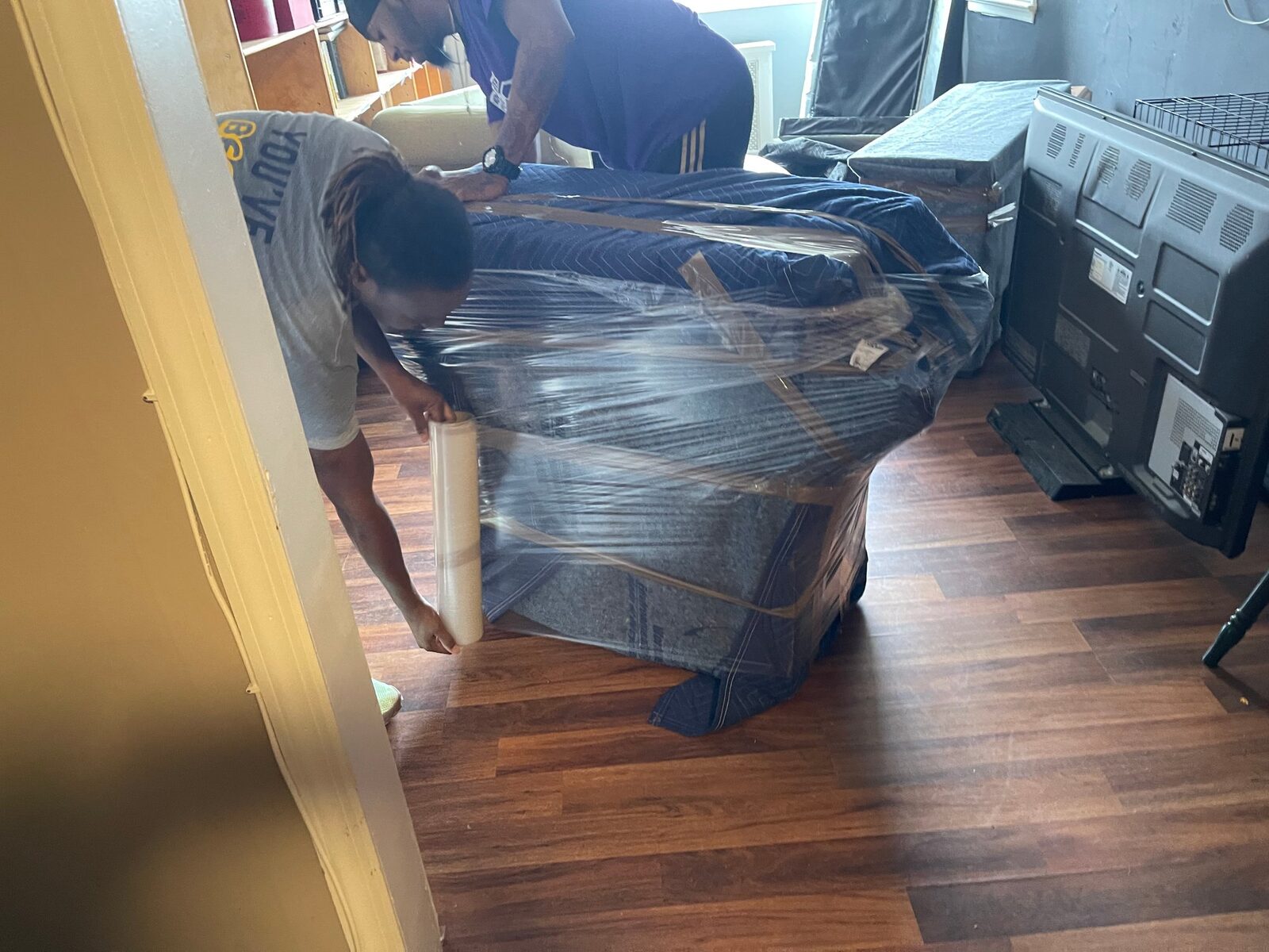 Royalty Moving crew wrapping furniture on a protected floor