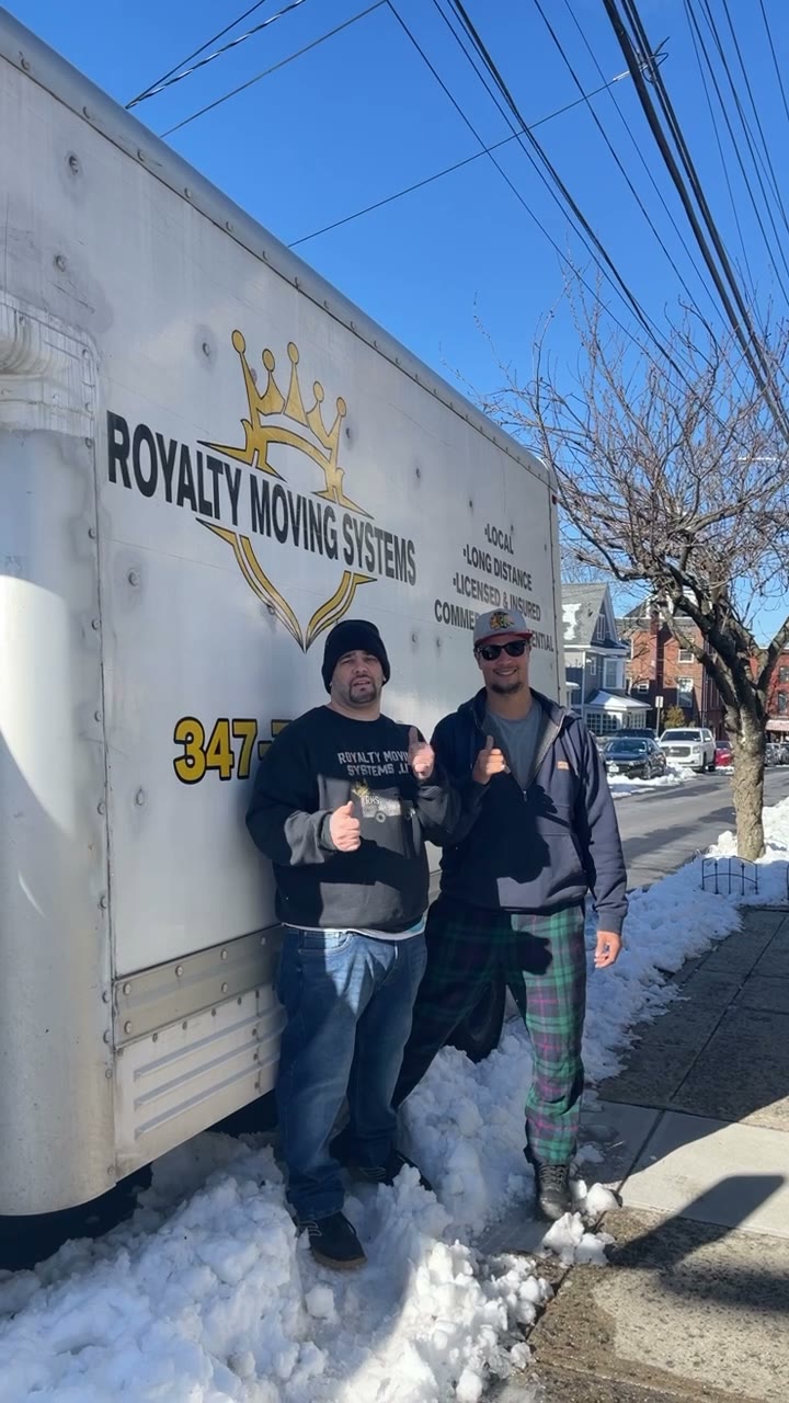 Two Royalty Moving crew members giving a thumbs up beside the branded box truck